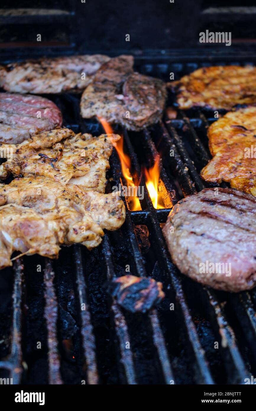 Meat being flame grilled on a barbecue, BBQ flame grill Stock Photo - Alamy