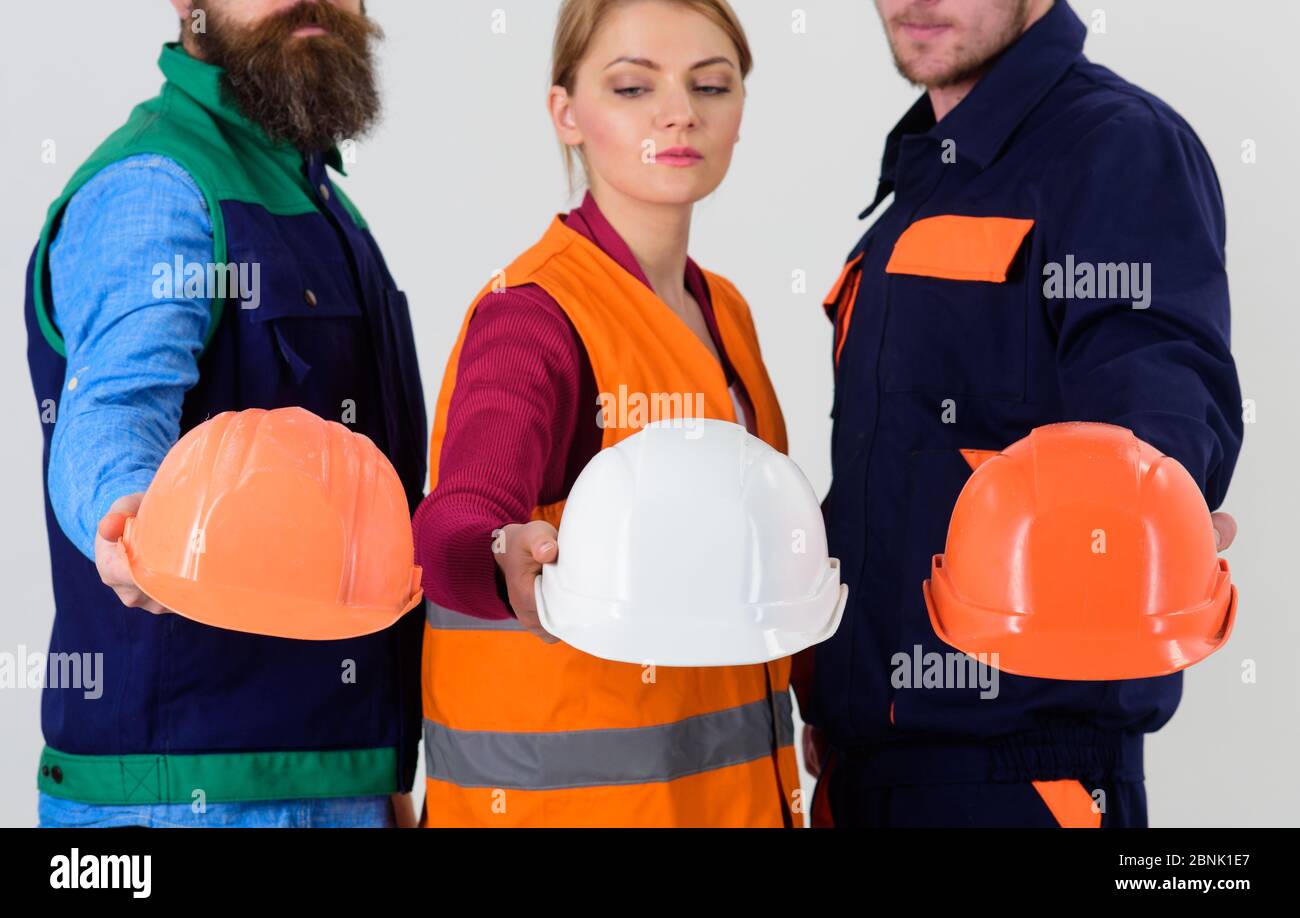Men and woman wears uniform and holds helmets or hard hats. Team of ...