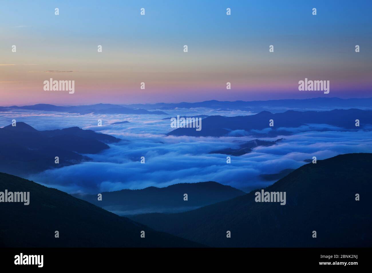 Sunrise in the mountains. The sun rises over the valleys covered with ...