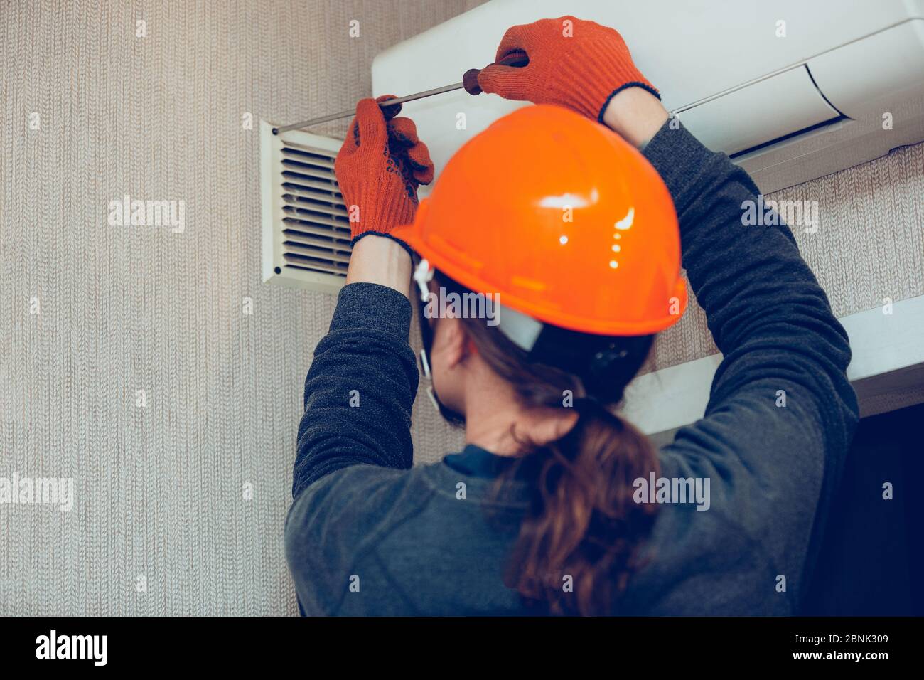 Industrial builder, handyman installing ventilation or air conditioning