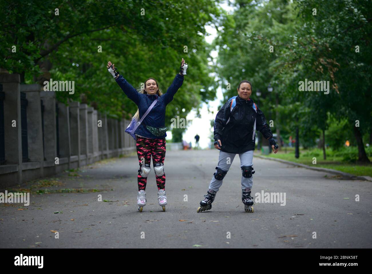 Smiling girls rollerblading in a park Stock Photo