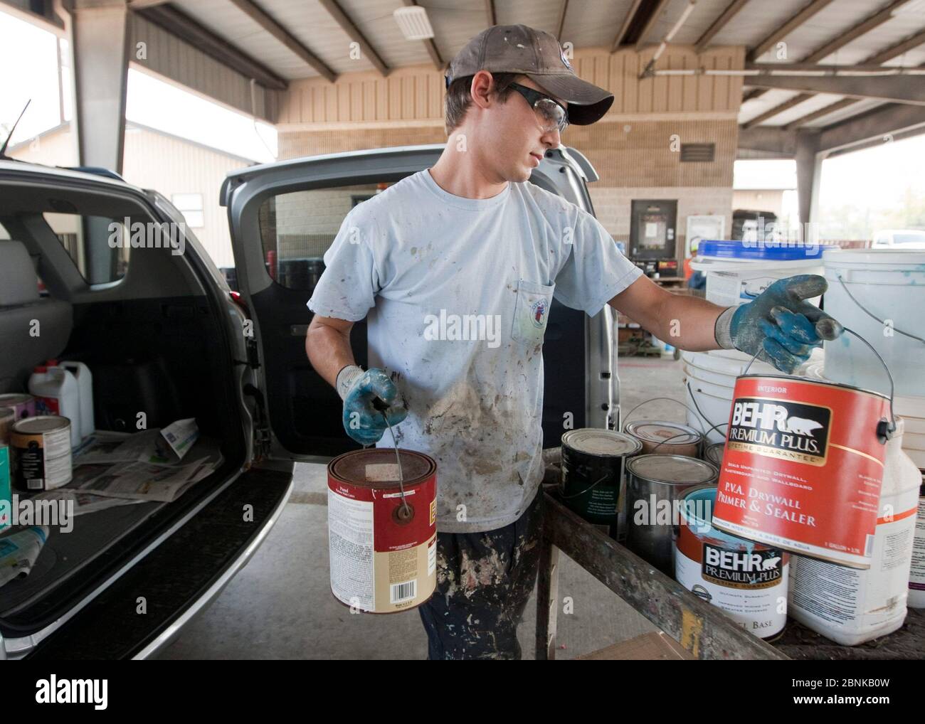 Austin Texas USA, 2012: Male employee at the City of Austin household hazardous waste facility unloads paint and other materials from vehicle brought in by a resident. The city-run facility allows residents to safely dispose of hazardous waste since putting these items in the trash or pouring down drains is dangerous and harmful to the environment. ©Marjorie Kamys Cotera/Daemmrich Photography Stock Photo