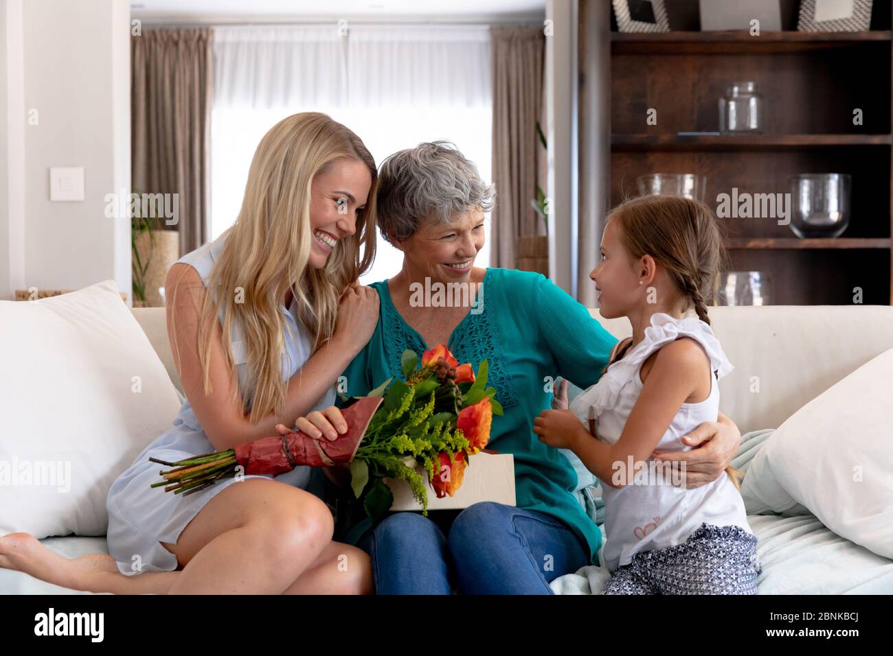 Senior Caucasian woman spending time with her daughter and her granddaughter at home Stock Photo