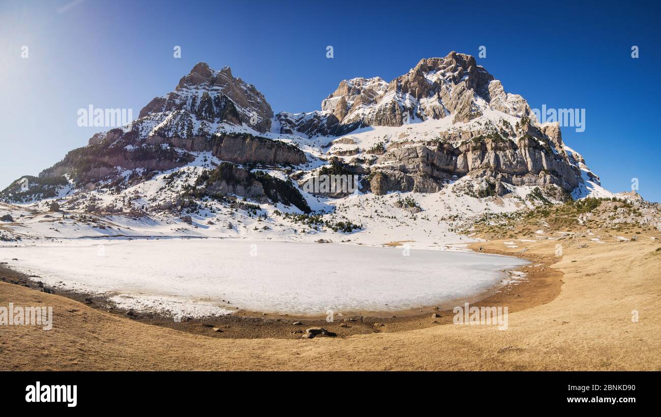 Frozen lake and snowy mountain on a sunny winter day Stock Photo