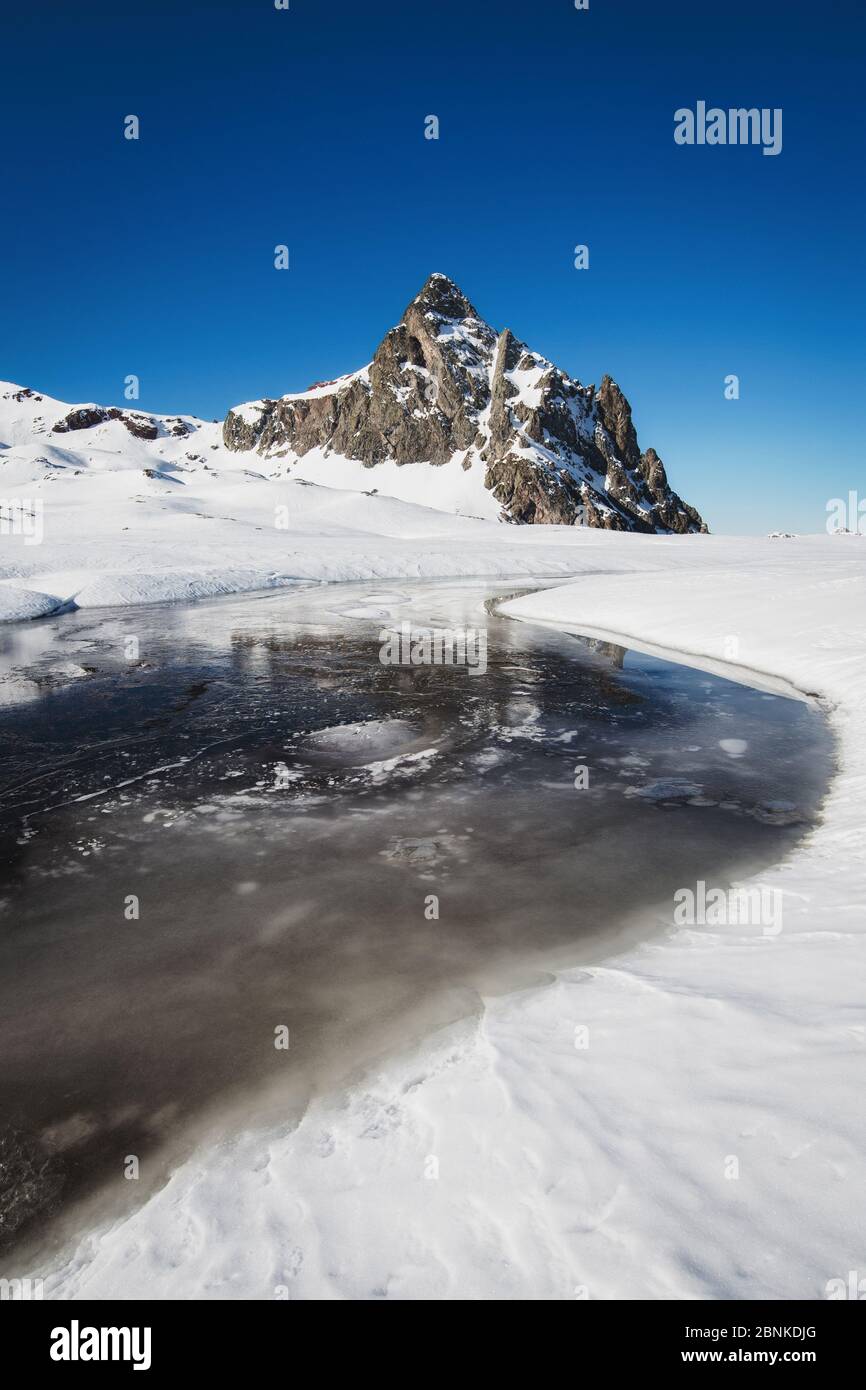 Winter landscape with a beautiful snowy mountain reflected in a lake Stock Photo