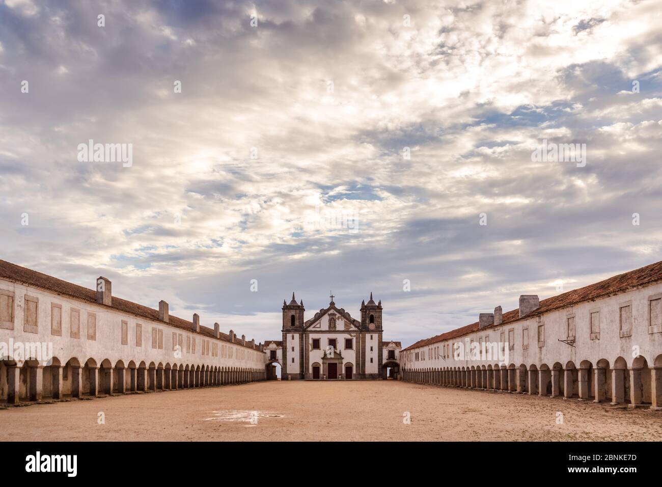 The Nossa Senhora do Cabo, Cabo Espichel, Sesimbra, Setubal peninsula, with its archs leading to the main building, on a cloudy day with sun shining Stock Photo