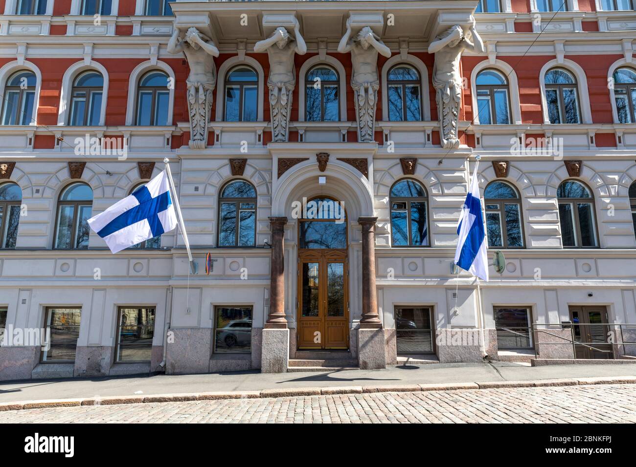 Historical building facade in Helsinki with Finnish flags flying Stock Photo
