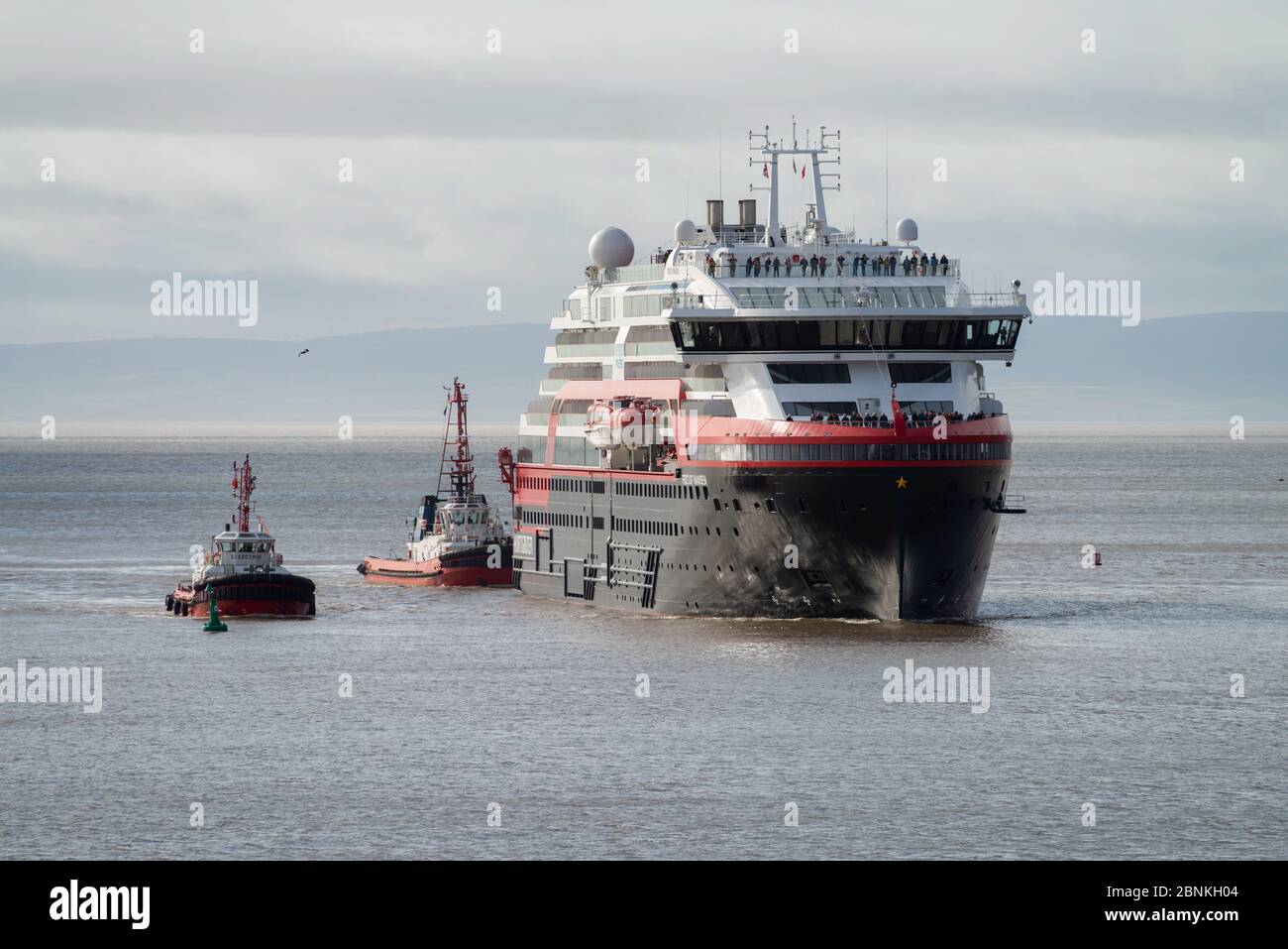 The green-powered cruise vessel MV Fridtjof Nansen approaches Cardiff docks today Saturday 14/3/20 accompanied by two tug boats. Stock Photo