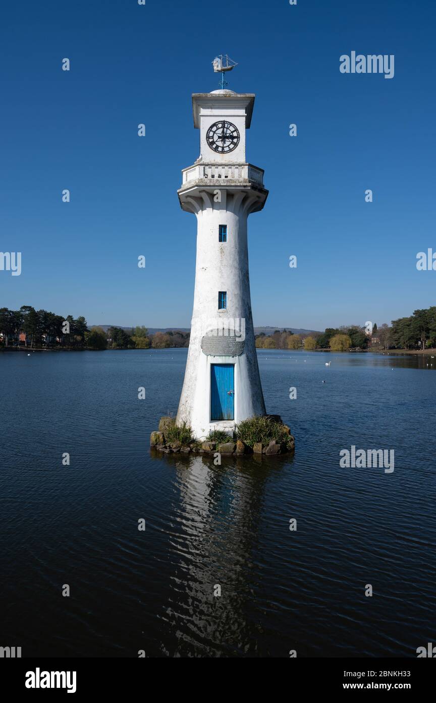 The Scott monument clock tower at Roath Park Lake, Cardiff under a blue ...
