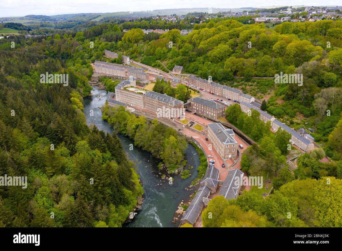 Aerial view of New Lanark World Heritage Site closed during covid-19 lockdown, beside River Clyde in South Lanarkshire, Scotland, UK Stock Photo