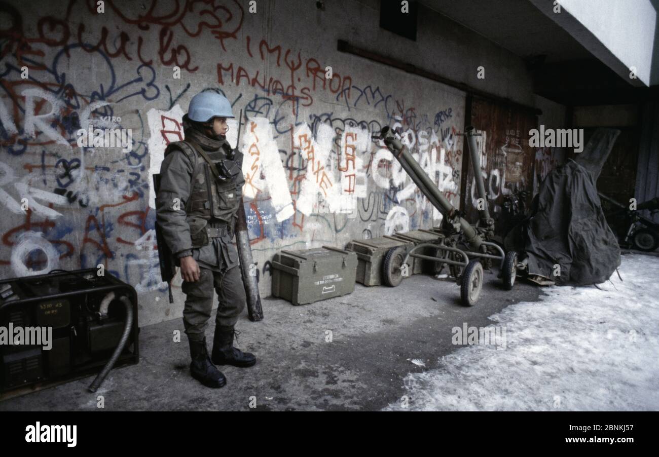 23rd February 1994 During the Siege of Sarajevo: a French soldier guards Bosnian-Serb weapons in a schoolyard in the Grbavica area of the city. Stock Photo