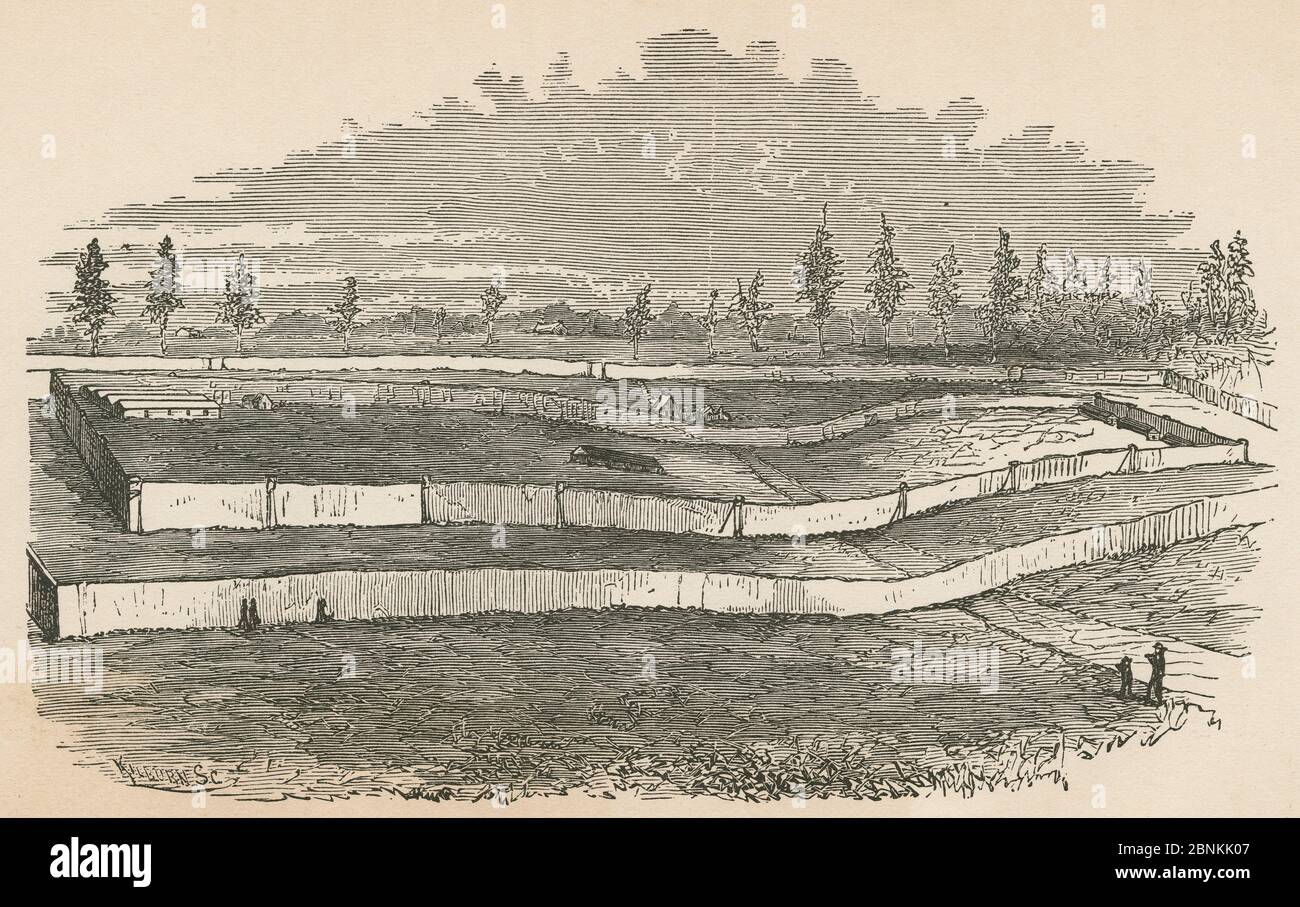 Antique 1866 engraving, “view of the stockade as the rebels left it” from The Soldier's Story by Goss. “The prison at Andersonville was situated on two hillsides, and through the center ran a sluggish brook, branch, as it was commonly called. There were no signs of vegetation in the pen; it had all been trampled out.” Andersonville Prison was a Confederate prisoner of war camp in Andersonville, Georgia, during the American Civil War. SOURCE: ORIGINAL ENGRAVING Stock Photo