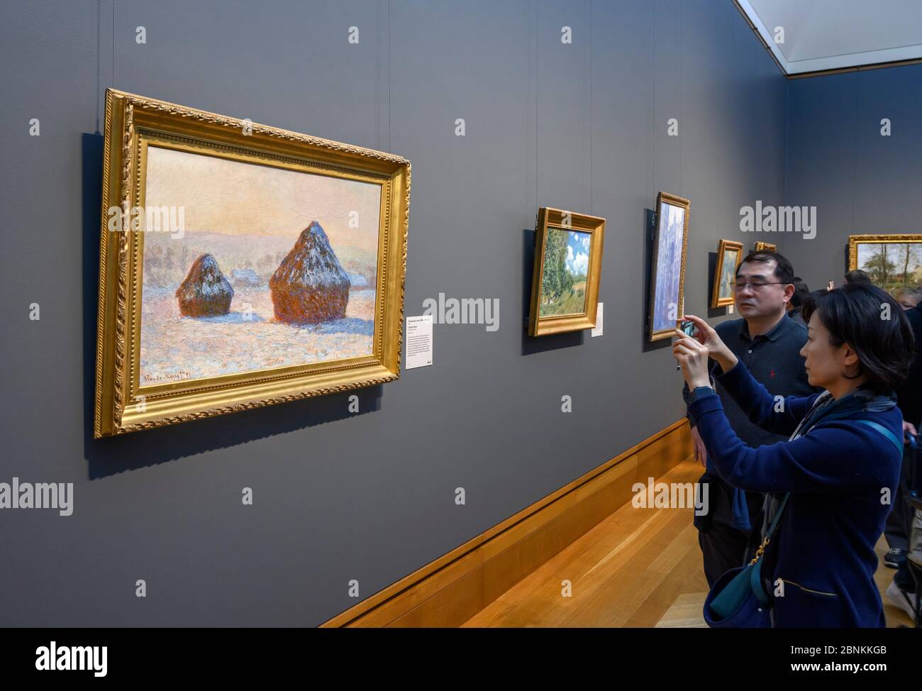 Visitors taking photographs of  Wheatstacks, Snow Effect, Morning (Meules, Effet de Neige, Le Matin) by Claude Monet, The Getty Center, Los Angeles, C Stock Photo