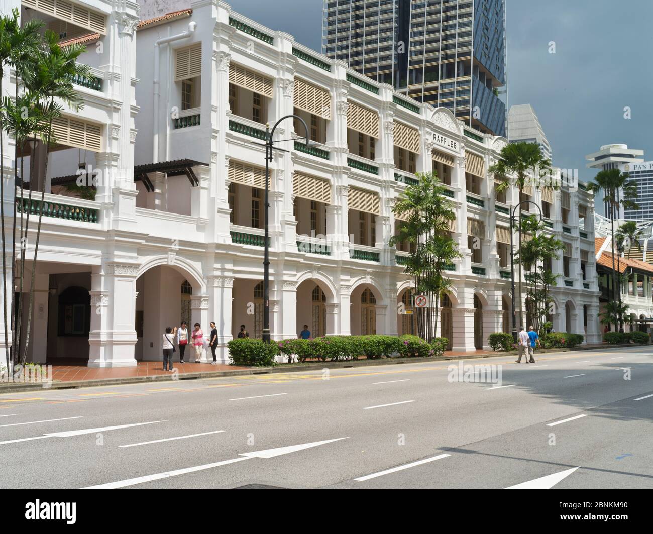 dh Traditional Colonial building RAFFLES HOTEL SINGAPORE Exterior people in street entrance asia Stock Photo