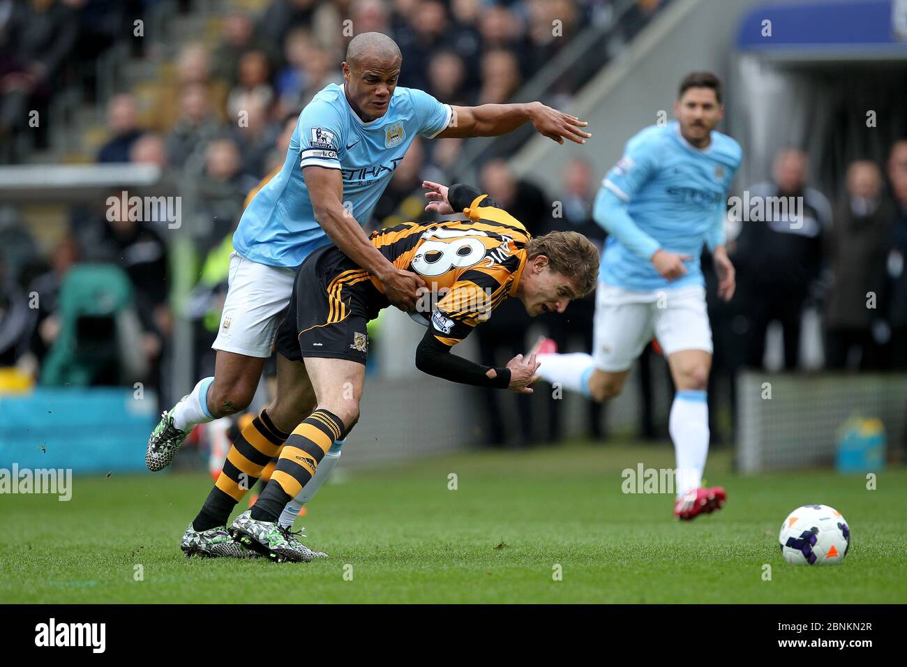 KINGSTON UPON HULL, ENGLAND - Vincent Kompany of Manchester City grapples with Nico Jelavic of Hull City during the Premier League match between Hull City and Manchester City at the KC Stadium, Kingston upon Hull on Saturday 15th March 2014 (Credit: Mark Fletcher | MI News) Stock Photo