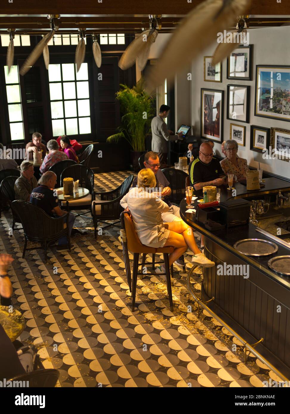 dh Long bar RAFFLES HOTEL SINGAPORE ASIA Tourist people relaxing with drinks pub Stock Photo