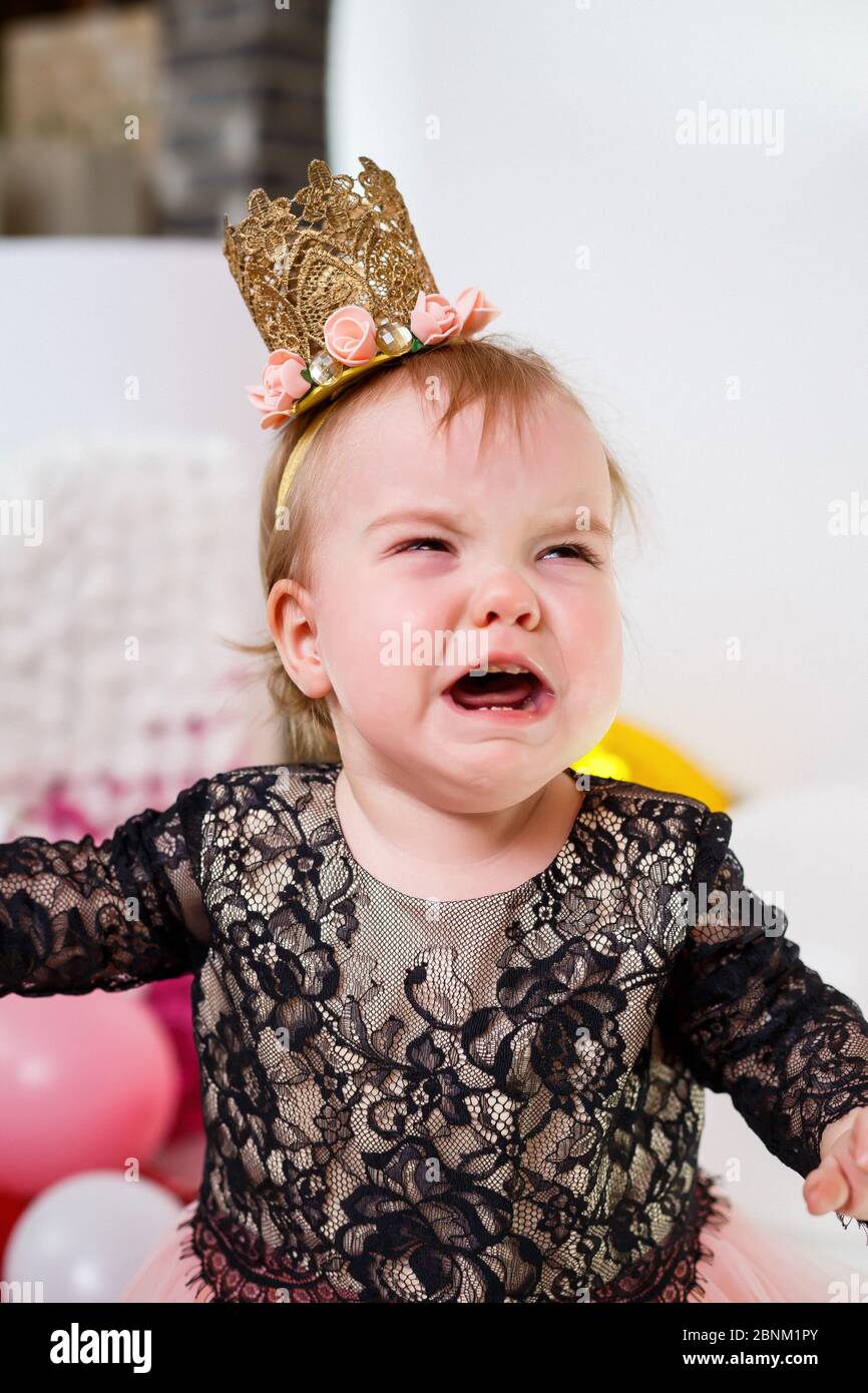 Photo portrait of a birthday girl 1 year old in a pink dress with pink  balloons. The child cries at the holiday, children's emotions. Girl crying  Stock Photo - Alamy