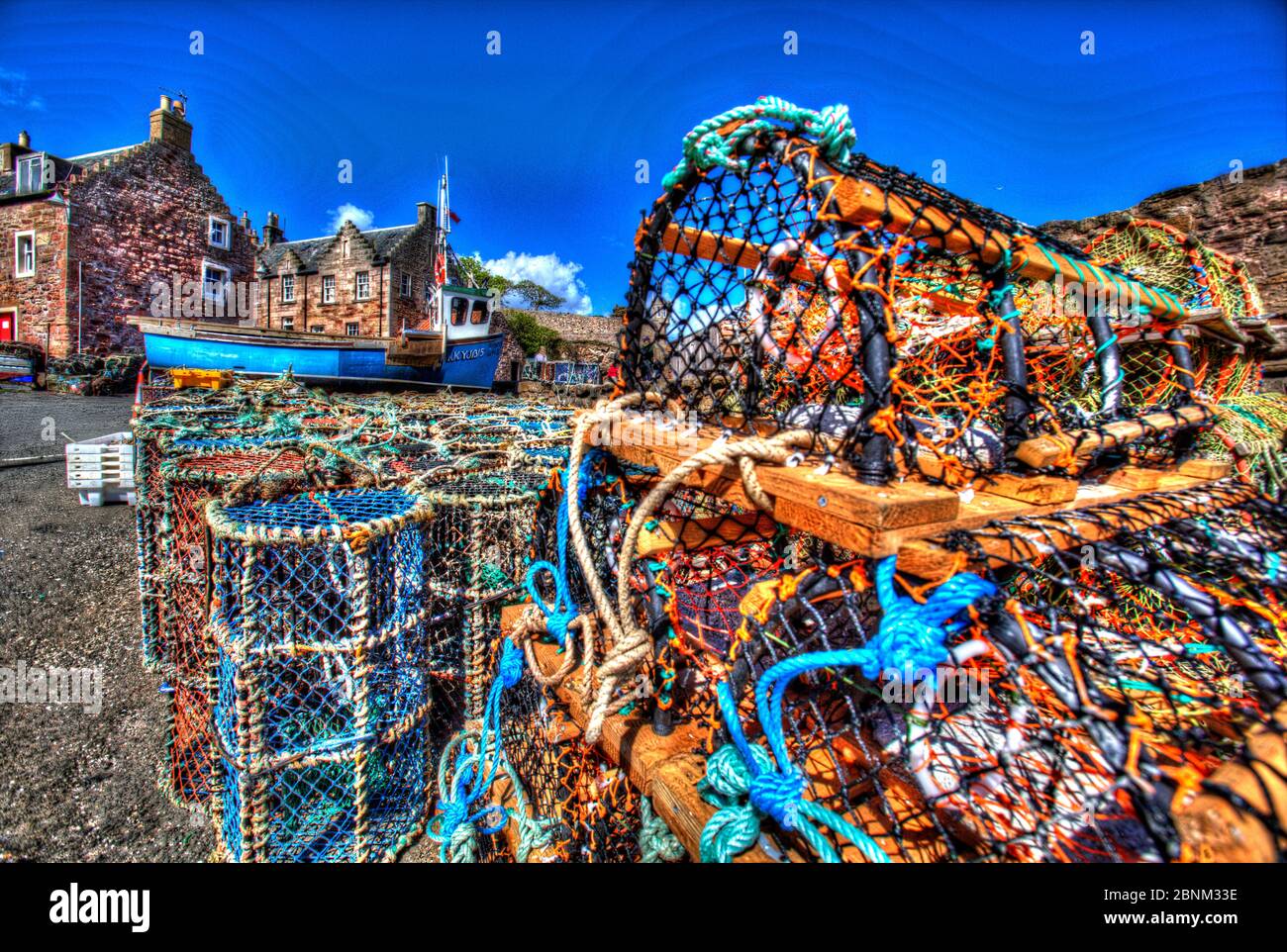 Town of Crail, Scotland. Artistic view of Crail quayside with lobster pots in the foreground and harbour residences in the background. Stock Photo