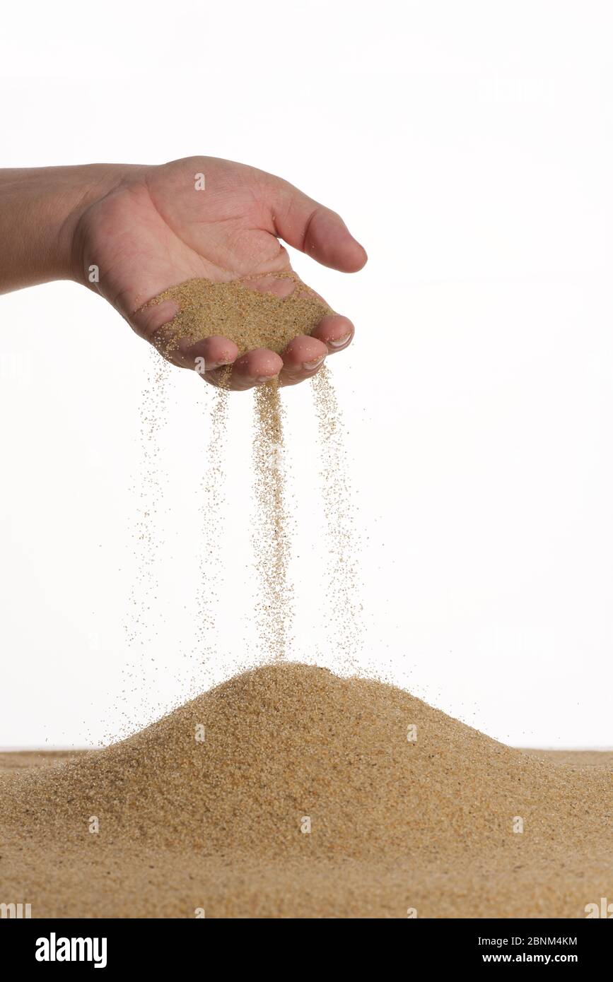 Stop motion. The male hand holds in the palm of the yellow sand. Sand flows down through your fingers. White background. Stock Photo