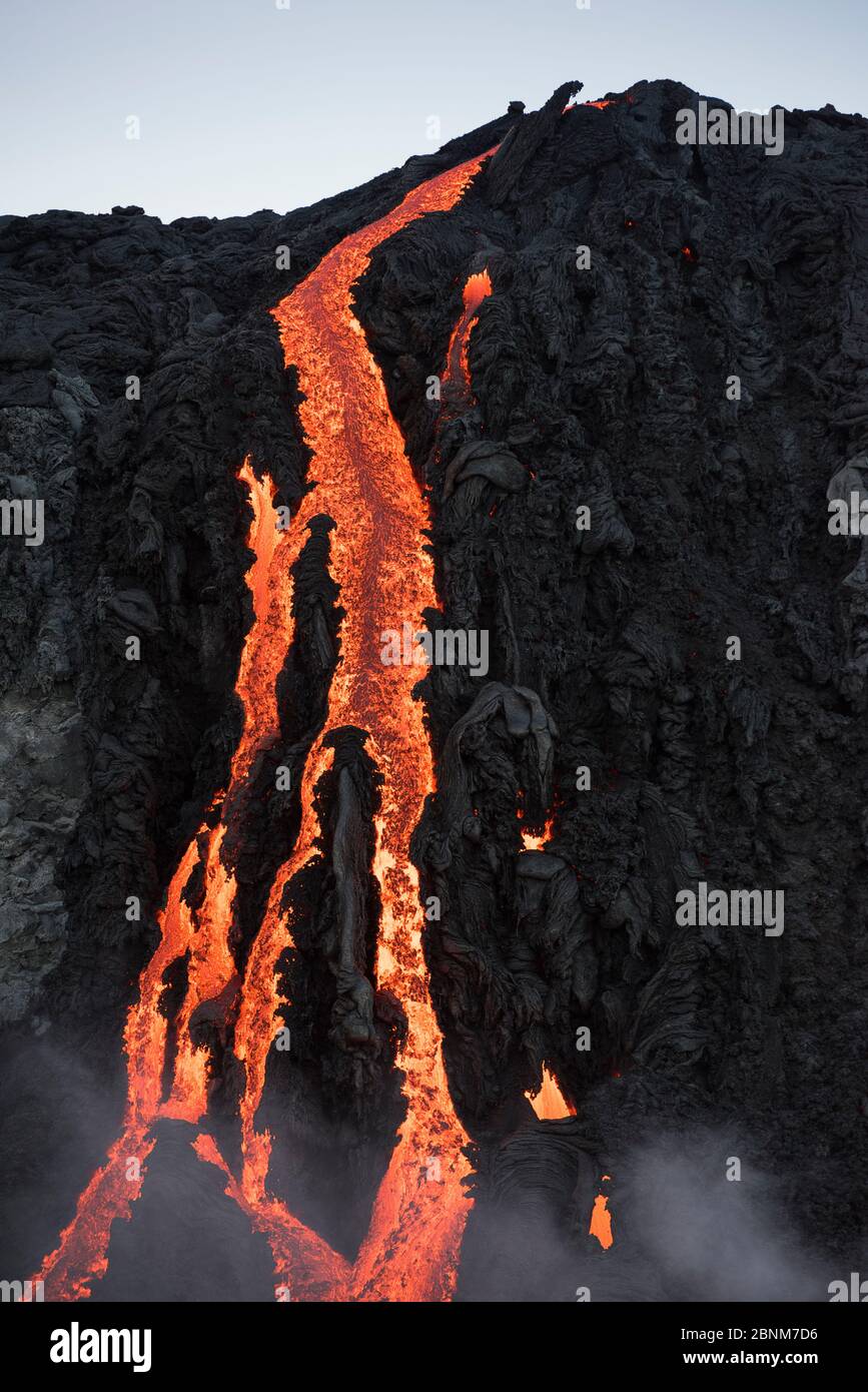 Hot lava from the 61G flow, emanating from Pu'u O'o on Kilauea Volcano, flows over seacliffs into the ocean on the first week of its ocean entry at Ka Stock Photo