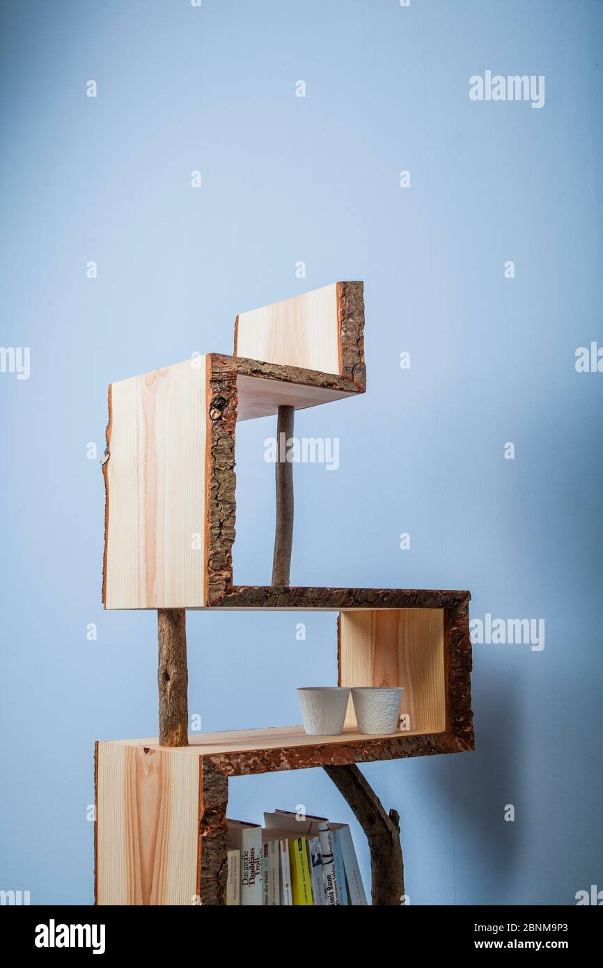 Construction of a wooden shelf, do-it-yourself production, final photo 04 against a light blue wall Stock Photo