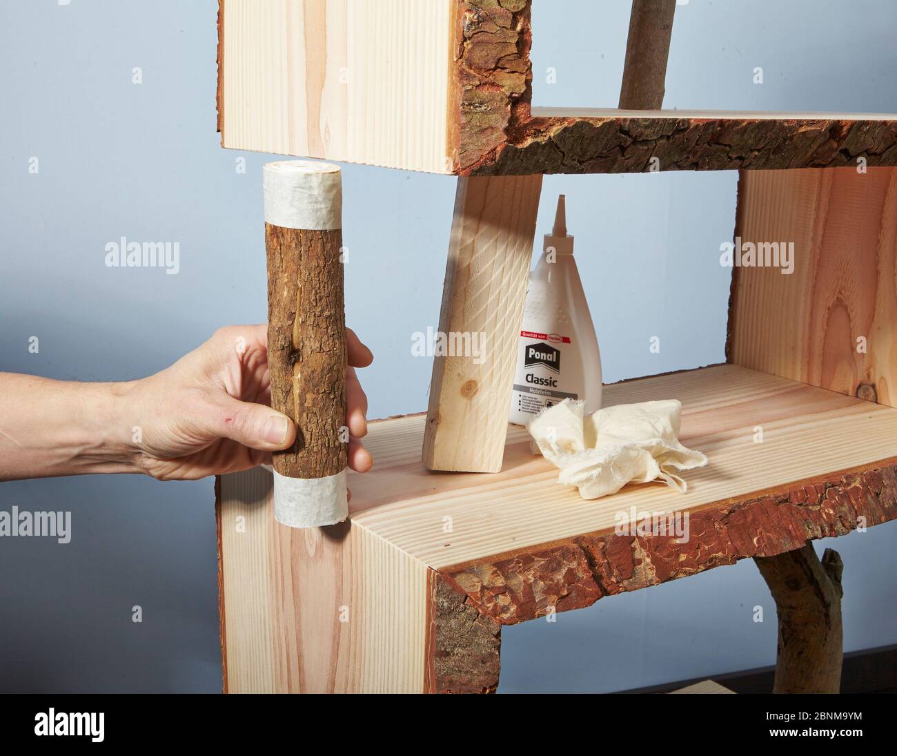 Construction of a shelf made of wood, do-it-yourself production, step-by-step, step 11 attaching the branch as a support, using auxiliary blocks and glue Stock Photo