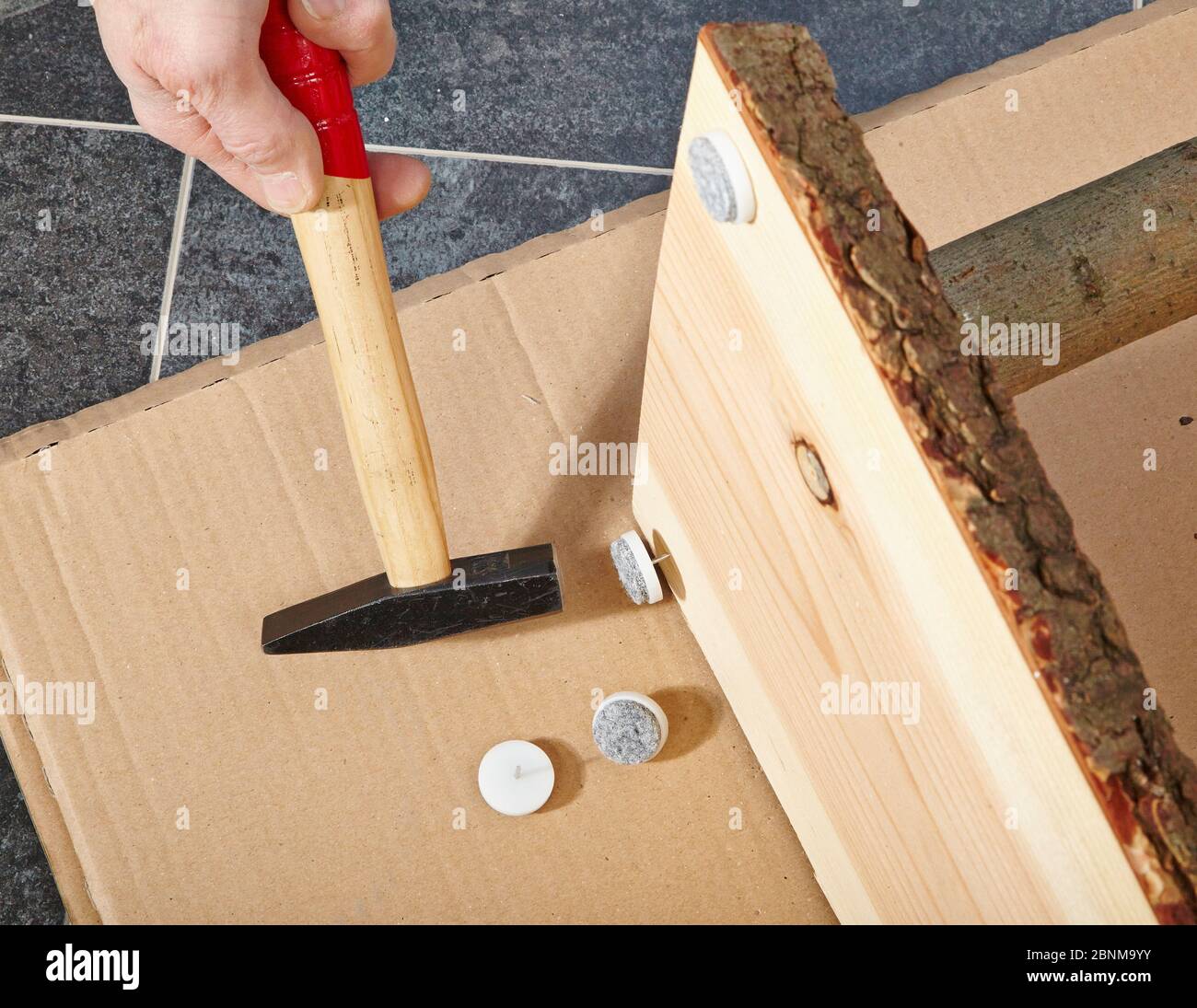 Construction of a wooden shelf, do-it-yourself production, step-by-step, step 13 Attaching felt pads to protect the floor and to prevent the shelf from wobbling Stock Photo