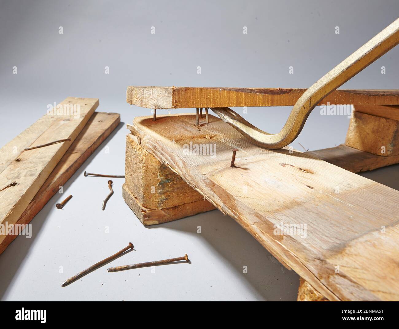 Construction of a shelf made of wood, Euro pallet, solid wood, MDF board; Do-it-yourself production, step-by-step, step 1 disassembly of the euro pallet, disassembly into individual parts with crowbar, pull out nail with nail iron Stock Photo