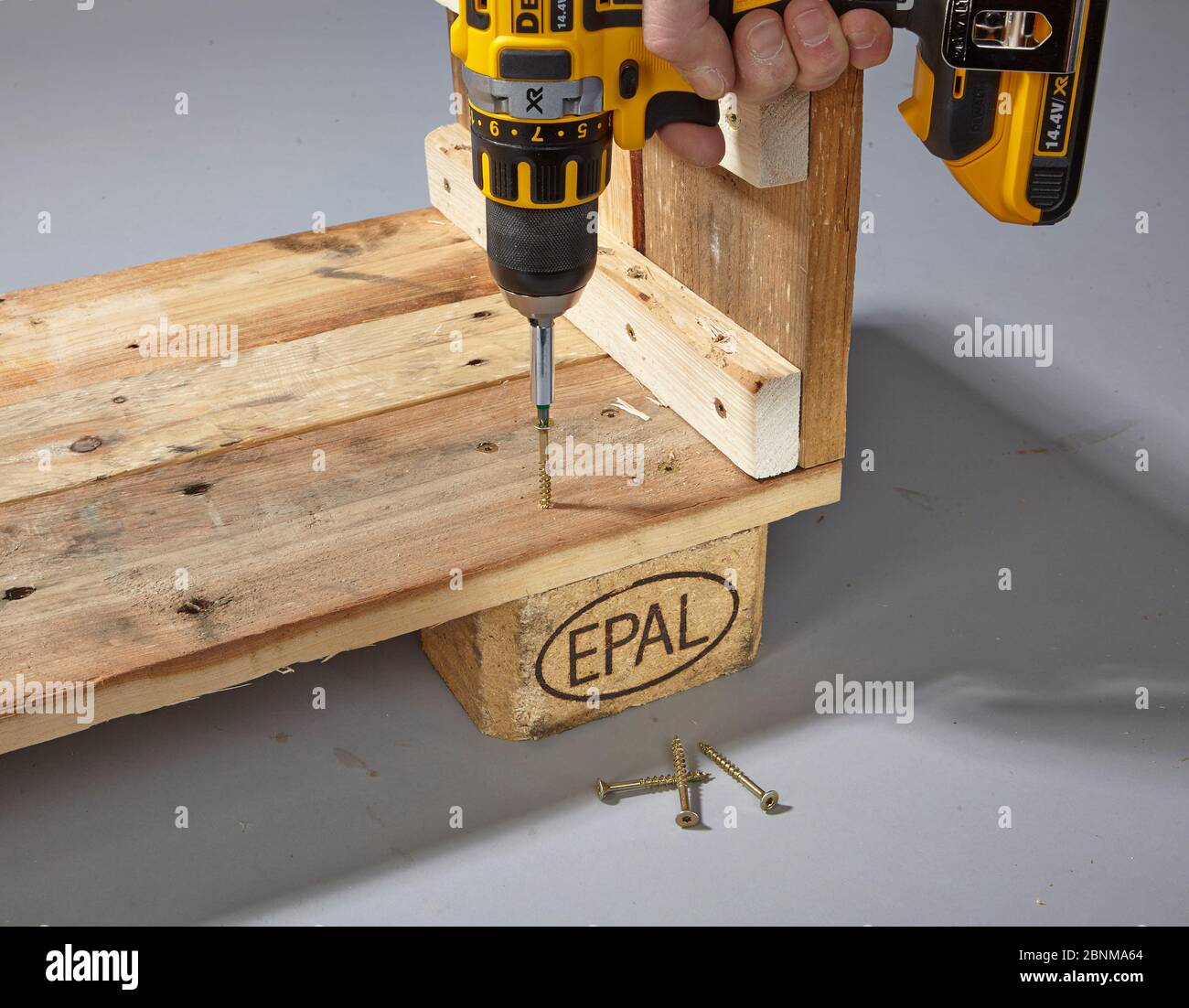 Construction of a shelf made of wood, Euro pallet, solid wood, MDF board; Do-it-yourself production, step-by-step, step 6: screwing on the blocks with the cordless screwdriver and wood screws Stock Photo