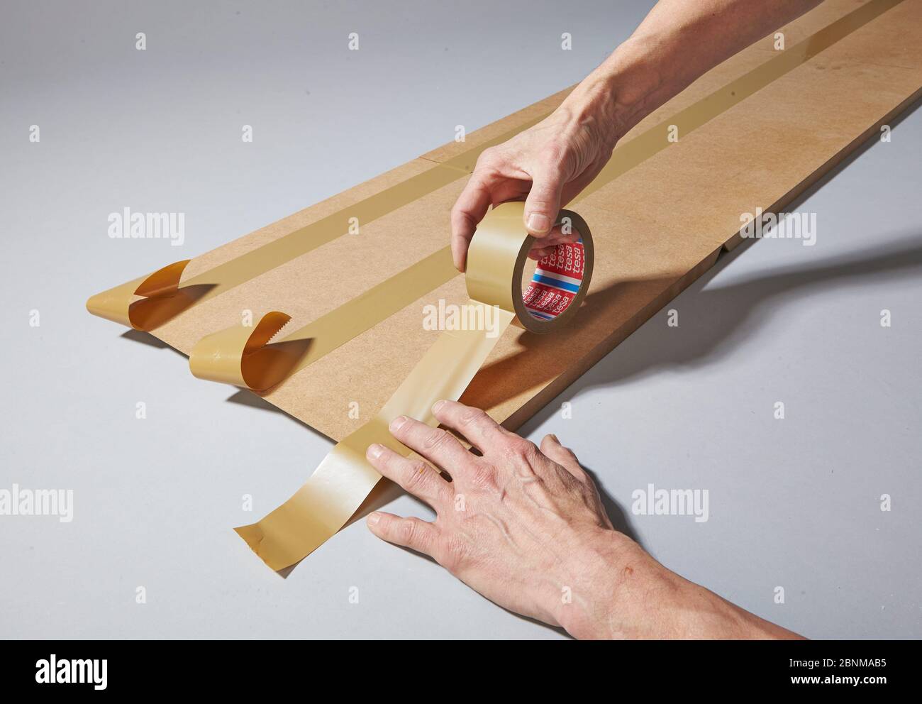 Construction of a shelf made of wood, Euro pallet, solid wood, MDF board; Do-it-yourself production, step-by-step, step 8b, put MDF boards together and connect with tape or parcel tape Stock Photo