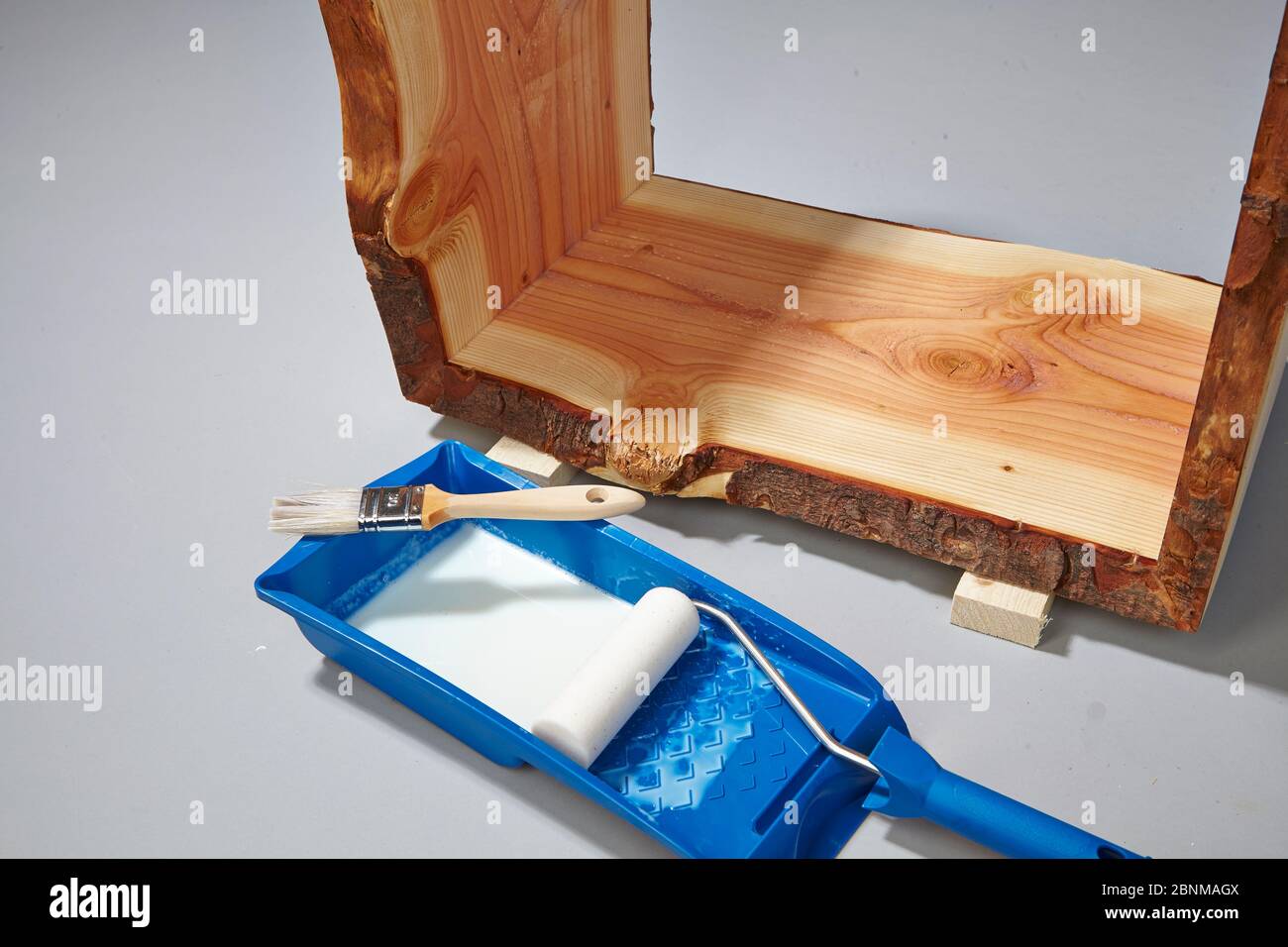 Building a wooden shelf, do-it-yourself production, step-by-step, step 17c painting the finished glued furniture with water-soluble acrylic paint, first painting the corners with a brush, then painting the surfaces with a foam roller Stock Photo