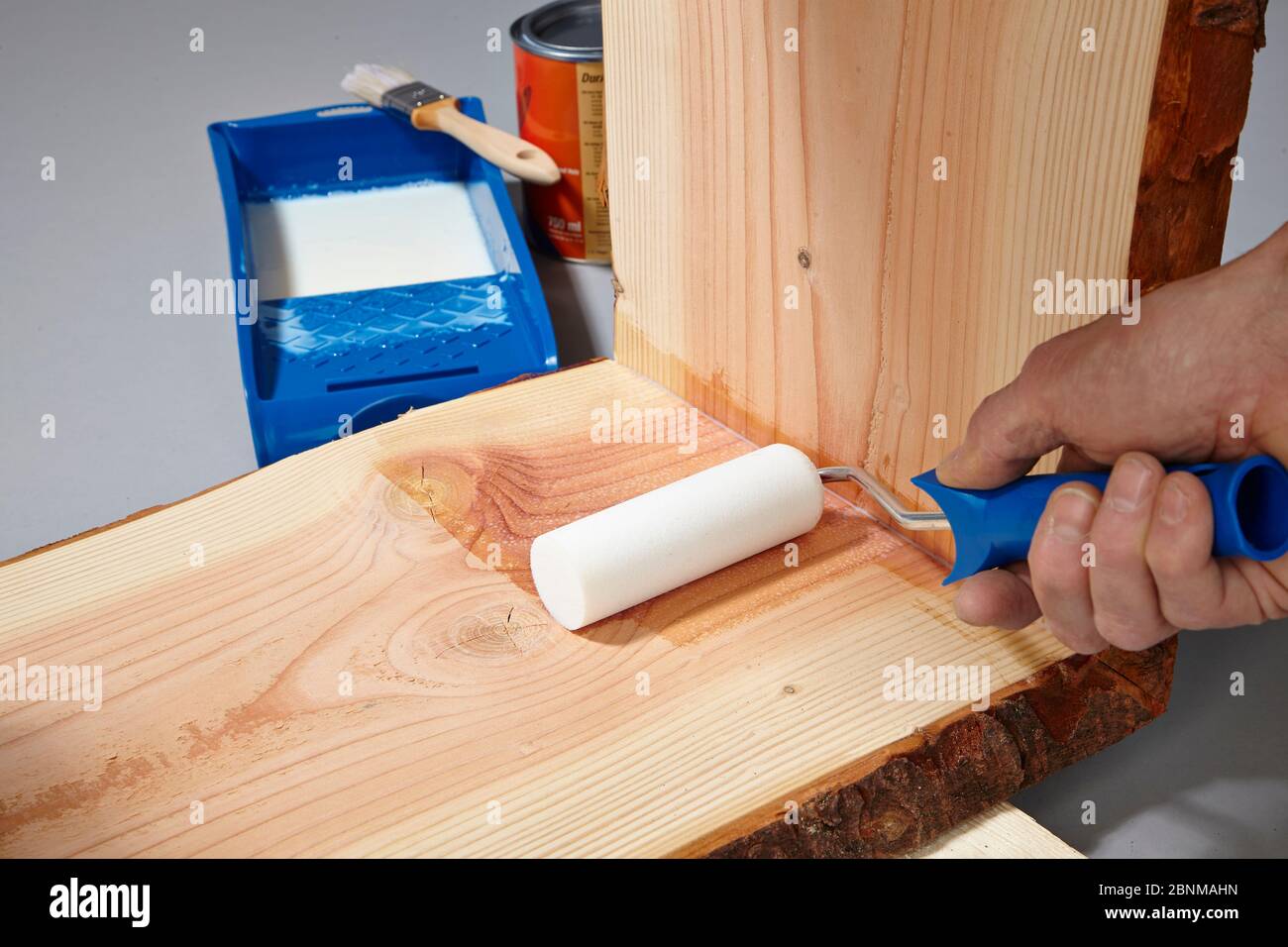 Building a wooden shelf, do-it-yourself production, step-by-step, step 17b painting the finished glued furniture with water-soluble acrylic paint, first painting the corners with a brush, then painting the surfaces with a foam roller Stock Photo