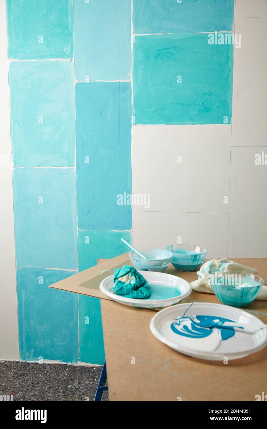 DIY wall design 02, step-by-step do-it-yourself production, various turquoise colored areas separated by white wooden strips, step 03a: paint the individual areas with different turquoise tones Stock Photo
