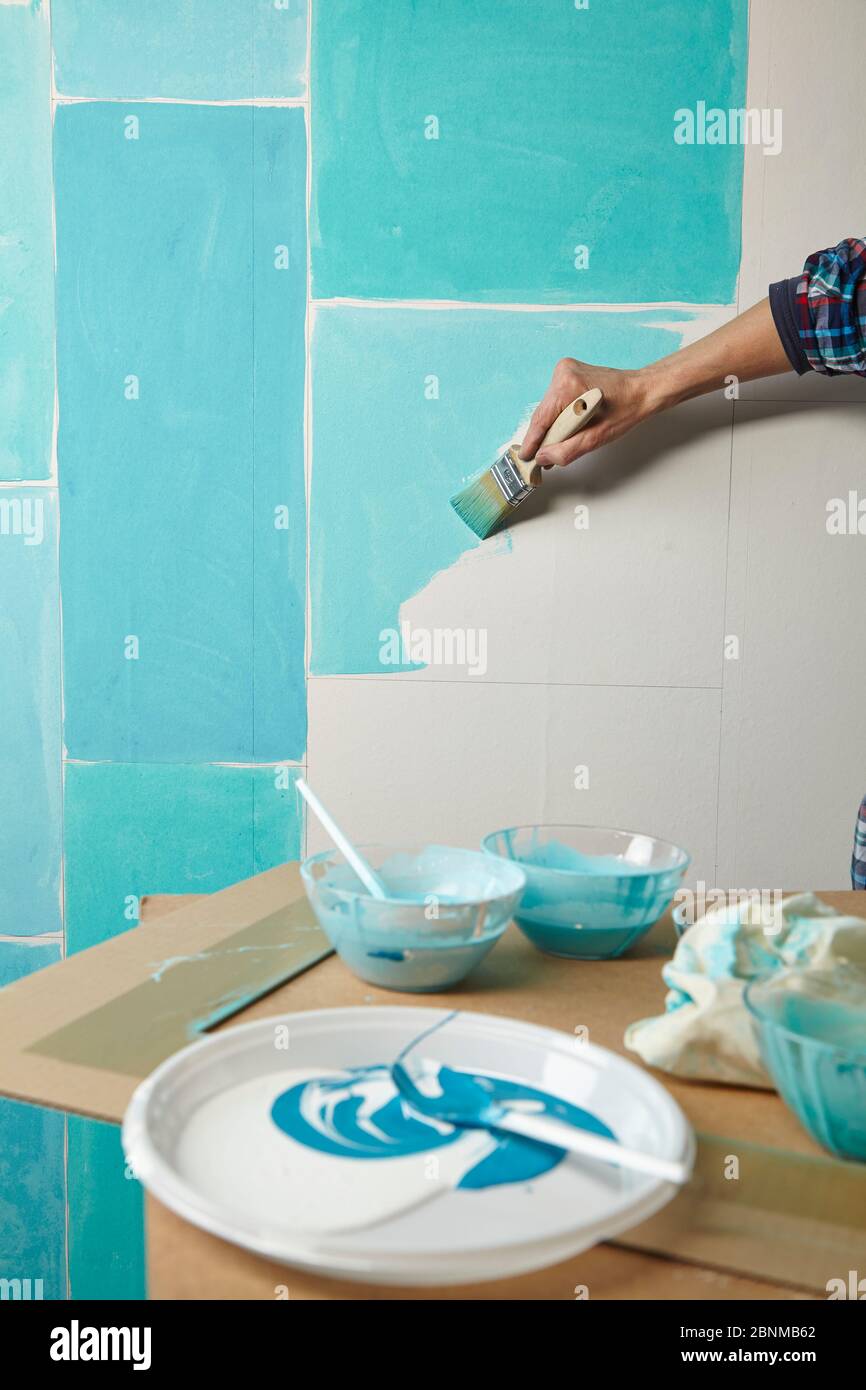 DIY wall design 02, step-by-step do-it-yourself production, various turquoise colored areas separated by white wooden strips, step 03b: painting the individual areas with different turquoise tones Stock Photo