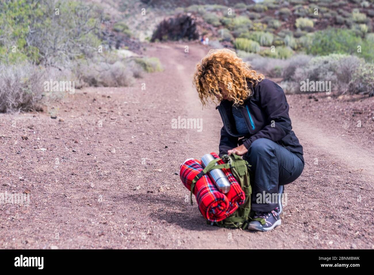 Sporty female with backpack checking equipment during a trekking expedition outdoor sport activity hiking and walking in the nature alternative travel concept with survival tools Stock Photo Alamy