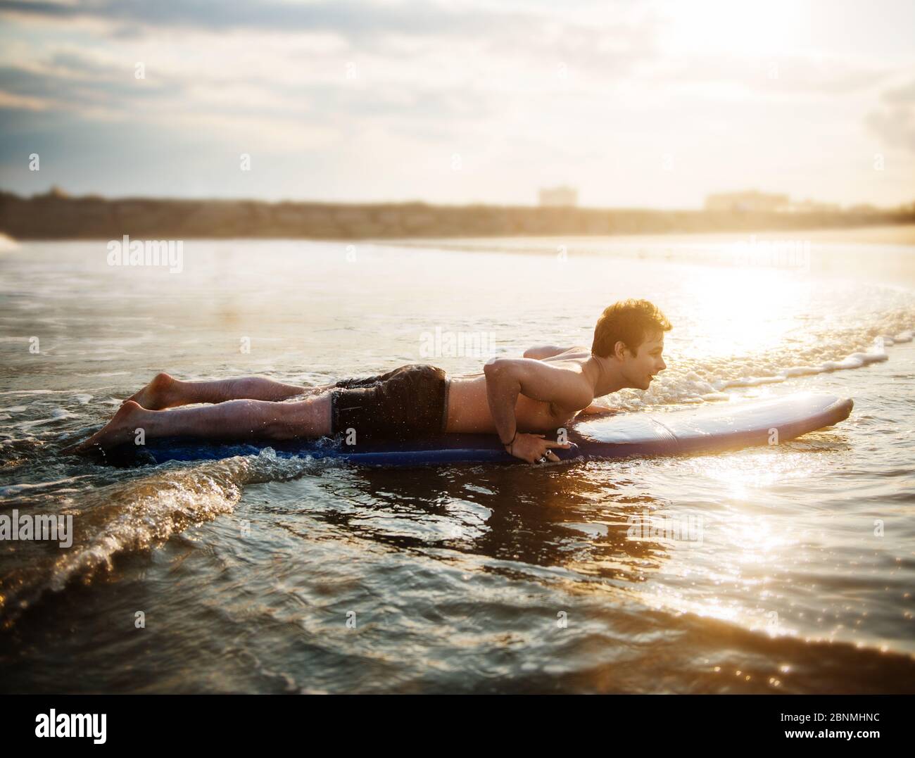 young man surfing on the beach Stock Photo - Alamy