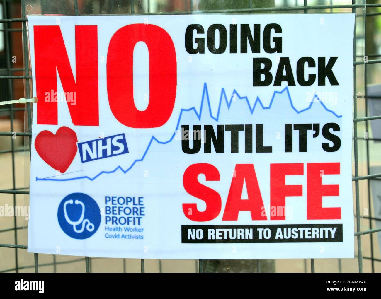 A poster in a street in Manchester, England, United Kingdom, May 15, 2020, calls for not going back to work until it's safe in the context of the Coronavirus or Covid 19 global pandemic. The poster includes the love NHS symbol, a 'people before profit' tag, and for 'no return to austerity'. Stock Photo