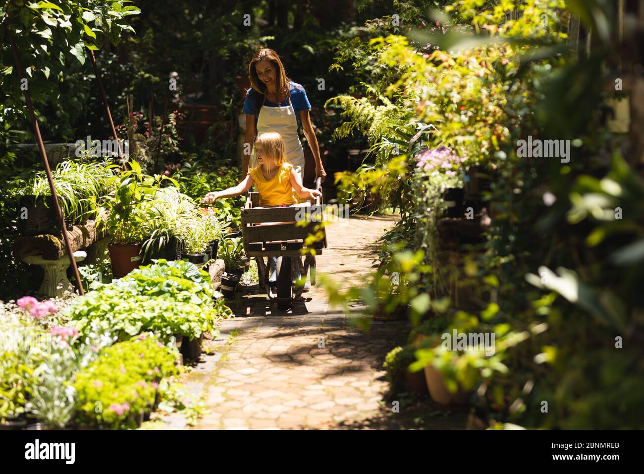 A Caucasian woman and her daughter sitting in a wheelbarrow Stock Photo ...