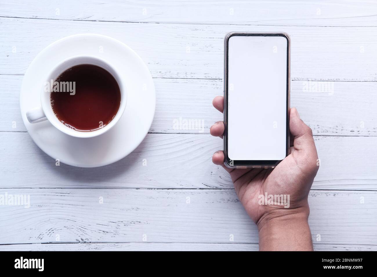 young man hand holding smart phone with empty screen  Stock Photo