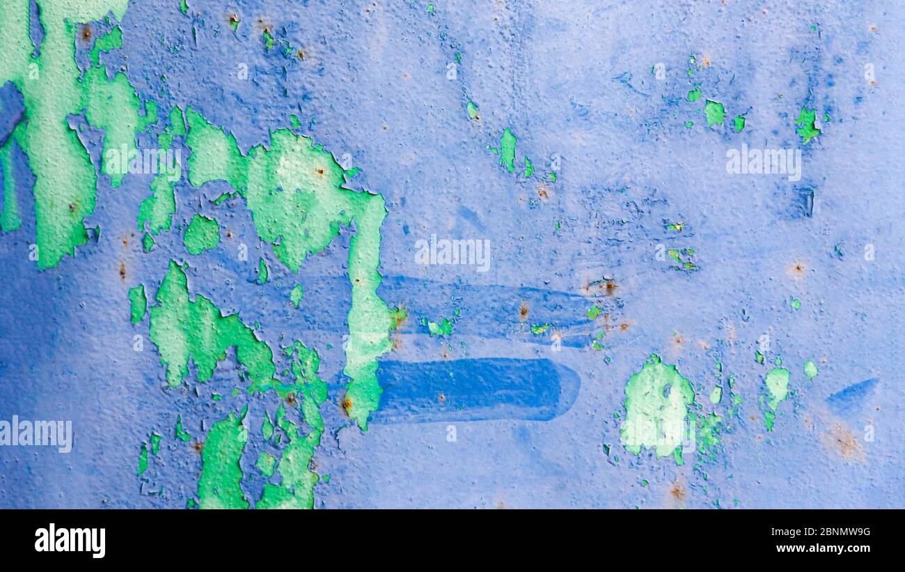 Old ragged cracked blue and green painted surface with rusty stains. Background texture, panoramic format, Stock Photo