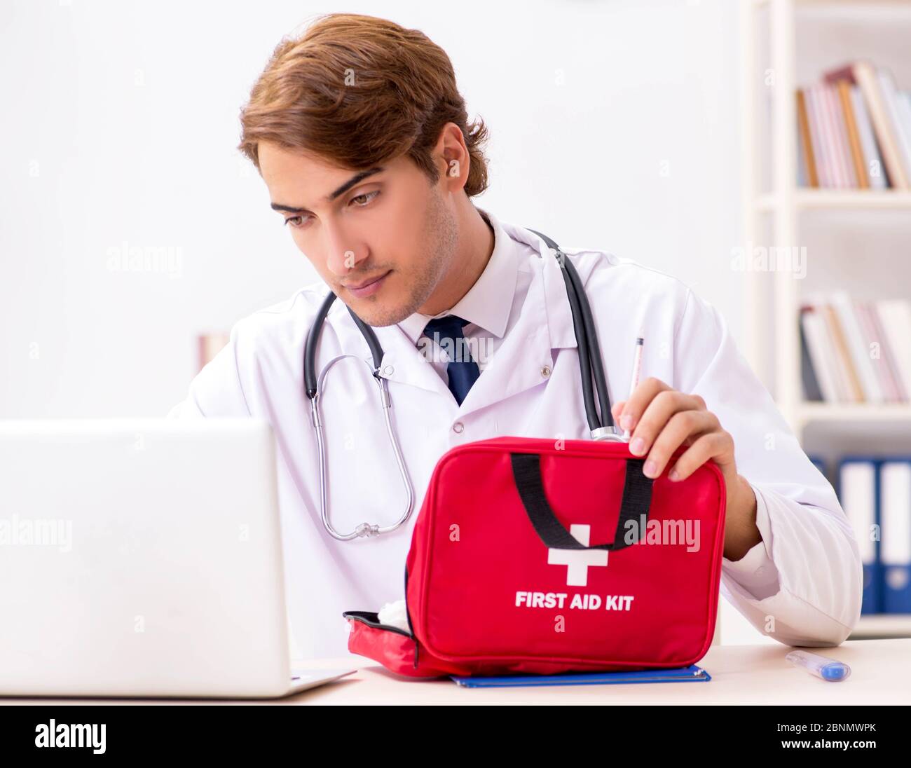 The young doctor with first aid kit in hospital Stock Photo - Alamy