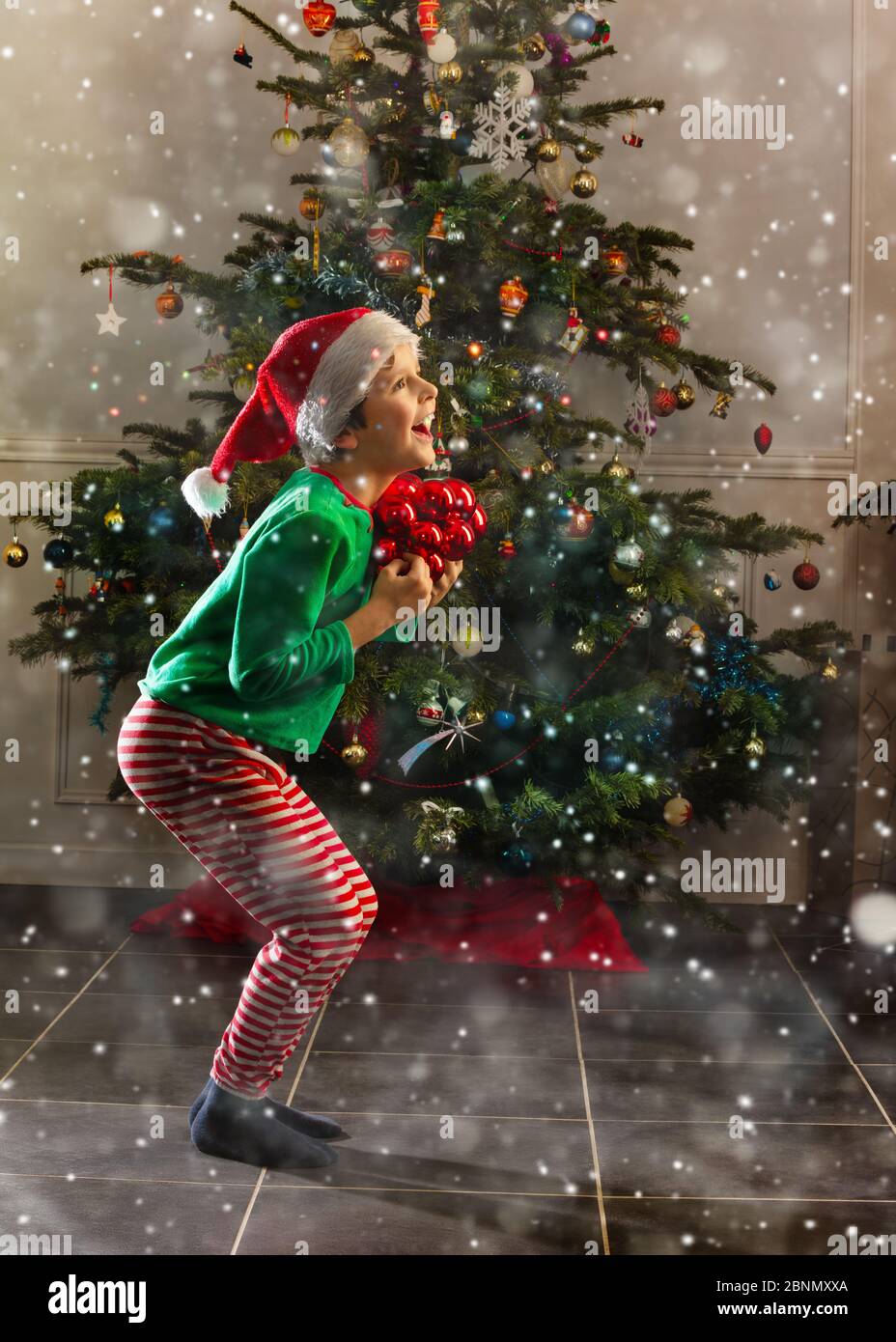 evne Geografi Gladys Happy jumping little boy jump from joy with New Year holiday decoration  balls near Christmas tree Stock Photo - Alamy