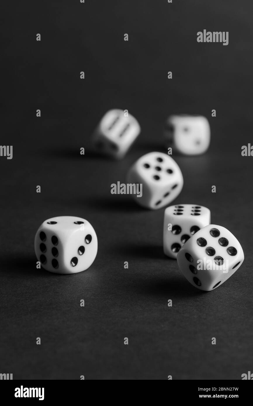 various tumbling dice on a black background in portrait format Stock Photo
