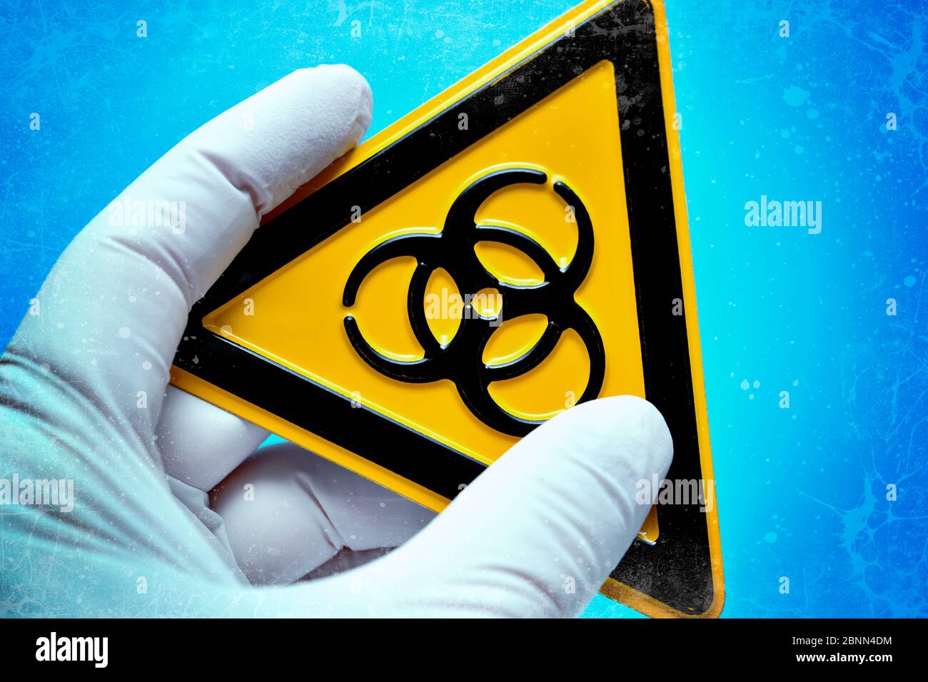 Biohazard sign is held by one hand in latex glove, symbolic photo of corona virus Stock Photo