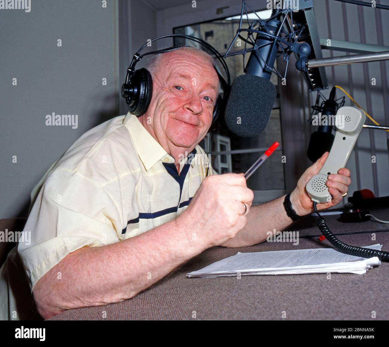 The popular Leipzig actor, cabaret artist and radio presenter Manfred Uhlig, also a loyal supporter of BSG Chemie Leipzig, moderates humorously in a Leipzig radio studio Stock Photo