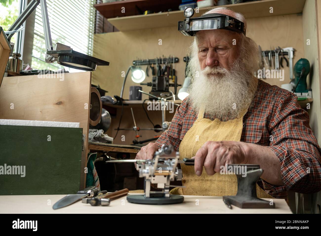 Male profession. Master knife sharpener working in the Studio Stock Photo