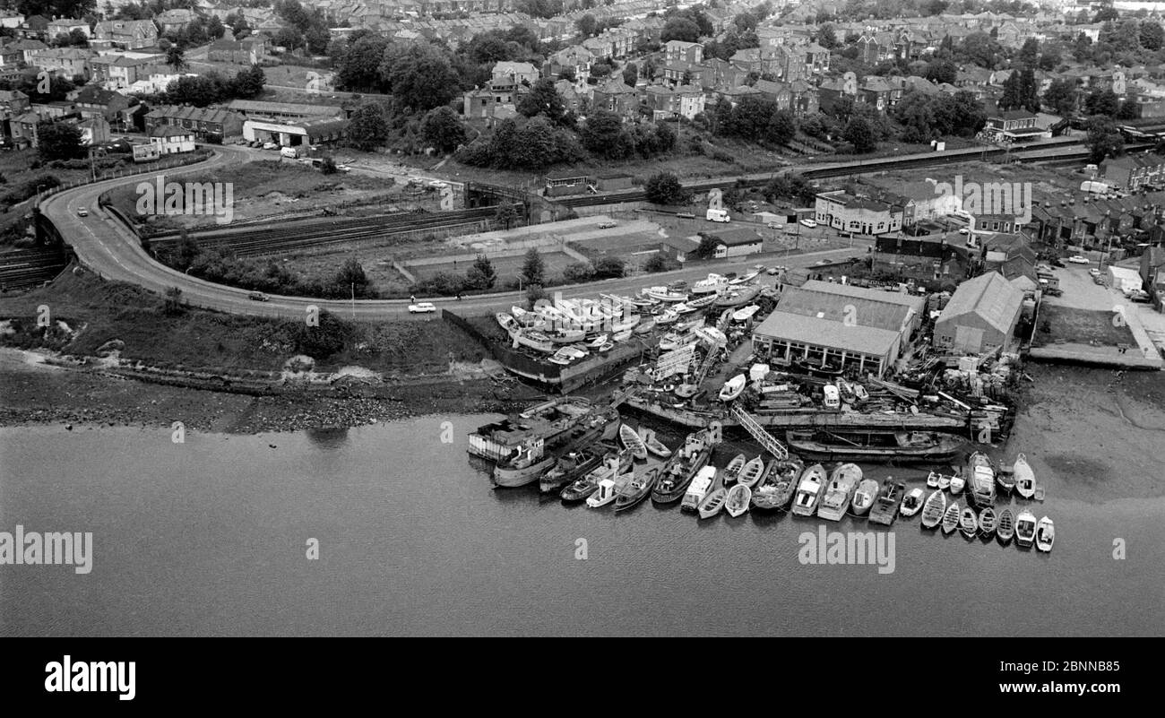 AJAXNETPHOTO. 1979. ST.DENYS, SOUTHAMPTON, ENGLAND. - ITCHEN RIVER BOATYARD - AERIAL VIEW OF BELSIZE BOATYARD WITH HORSESHOE BRIDGE ROAD SNAKING OVER MAIN SOUTHAMPTON RAIL LINE. BOATYARD SITE IS NOW QUAY 2000 RESIDENTIAL HOUSING. PHOTO:JONATHAN EASTLAND/AJAX REF:9061 Stock Photo