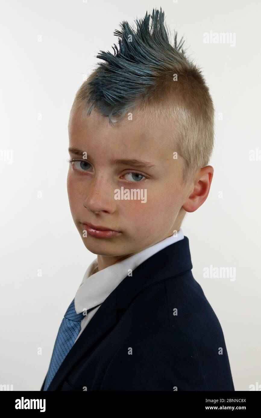 Portrait of a young male wearing a business suit with a blue mohawk looking serious Stock Photo