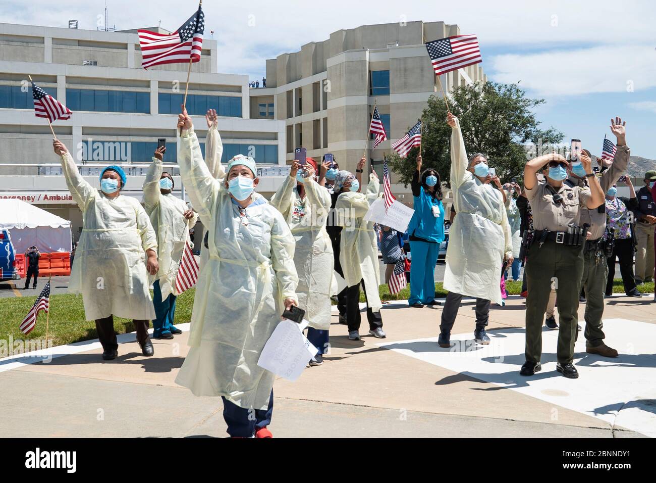 Moreno Valley, United States. 14th May, 2020. First responders and medical personnel wave and cheer as an U.S. Air Force KC-135 Stratotanker flies over the crowd at the Riverside University Health System Medical Cente, during the America Strong flyover May 14, 2020 in Moreno Valley, California. America Strong is a salute from the Navy and Air Force to recognize healthcare workers, first responders, and other essential personnel in a show of national solidarity during the COVID-19 pandemic. Credit: Nick Kibbey/U.S. Navy/Alamy Live News Stock Photo