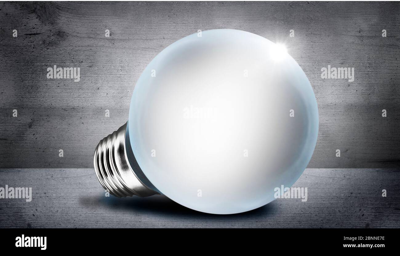 Glowing light bulb on gray background with bokeh effect Stock Photo